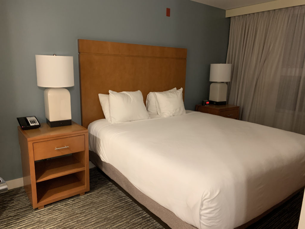 a bed with white sheets and a wooden headboard