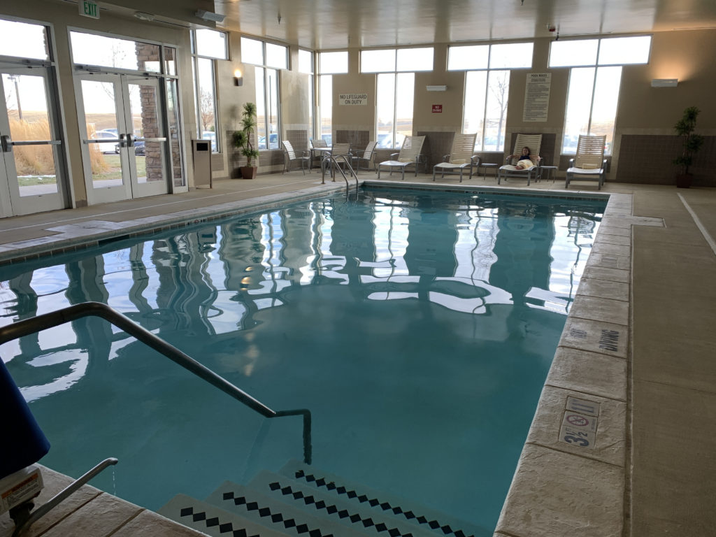 a pool with chairs and a person sitting in it