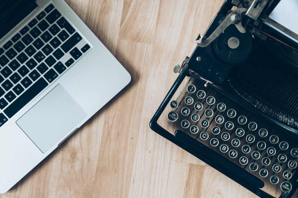 a typewriter and a laptop