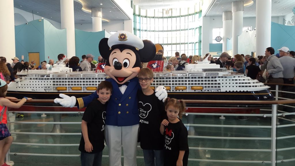 a group of kids posing with a person in a garment