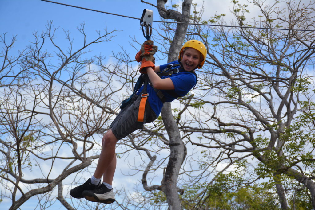 a person in a harness from a zip line