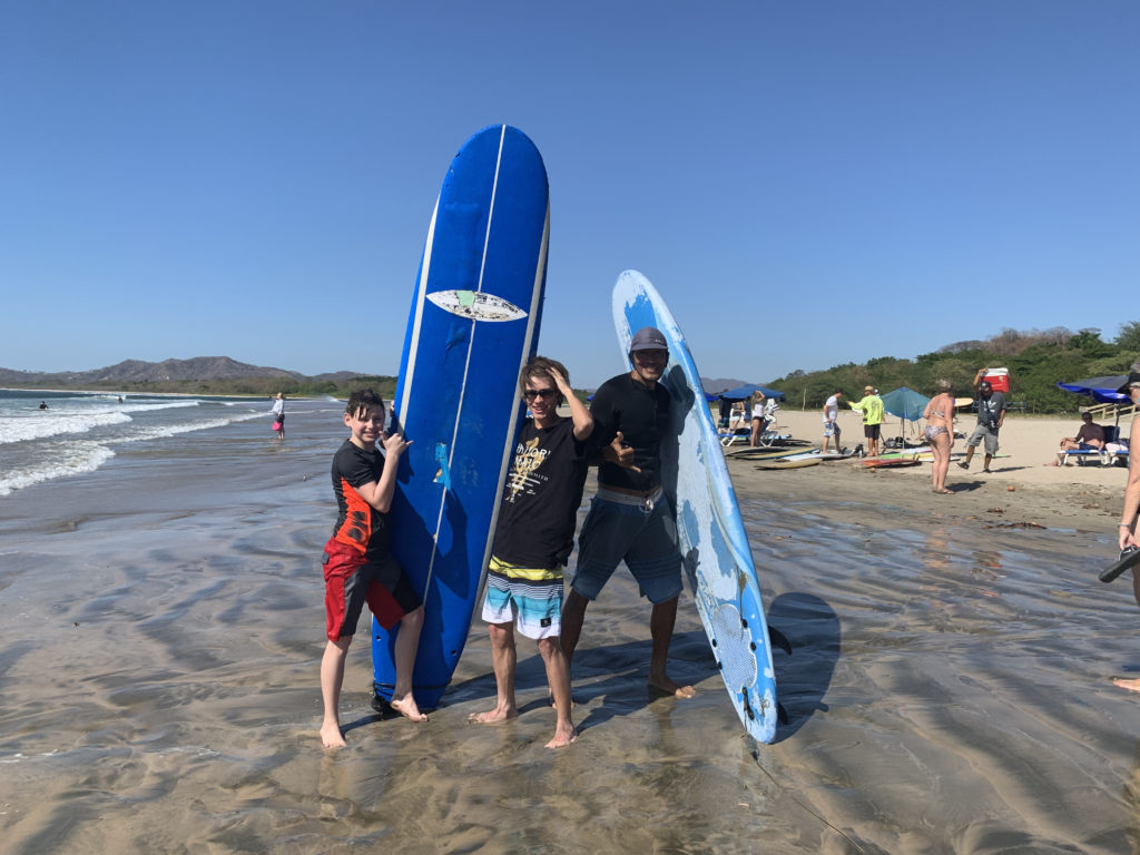a group of people standing on a beach with surfboards