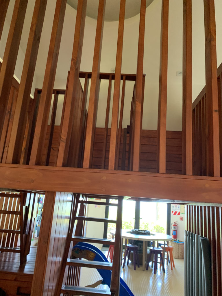 a wooden staircase with a table and chairs