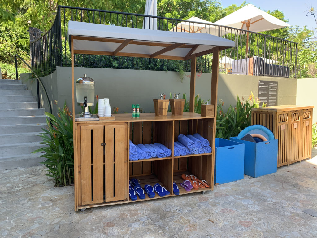 a wooden shelving unit with towels and sandals