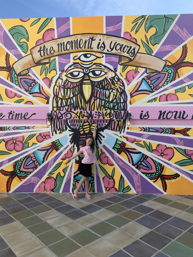 a girl posing in front of a mural