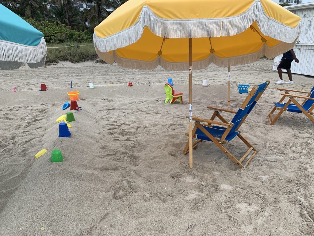 a beach with chairs and umbrella