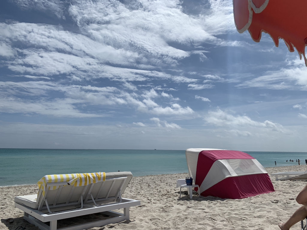 a beach with chairs and a tent