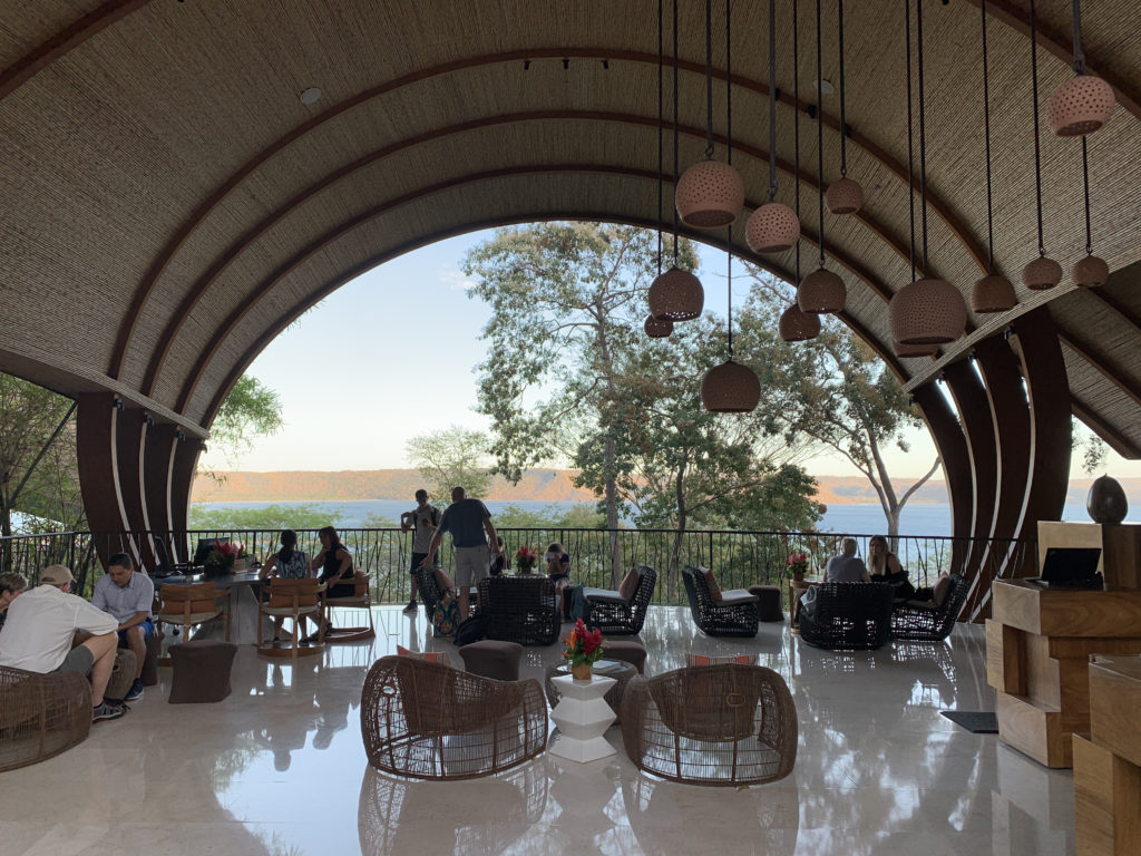 a group of people sitting in a room with a view of the water