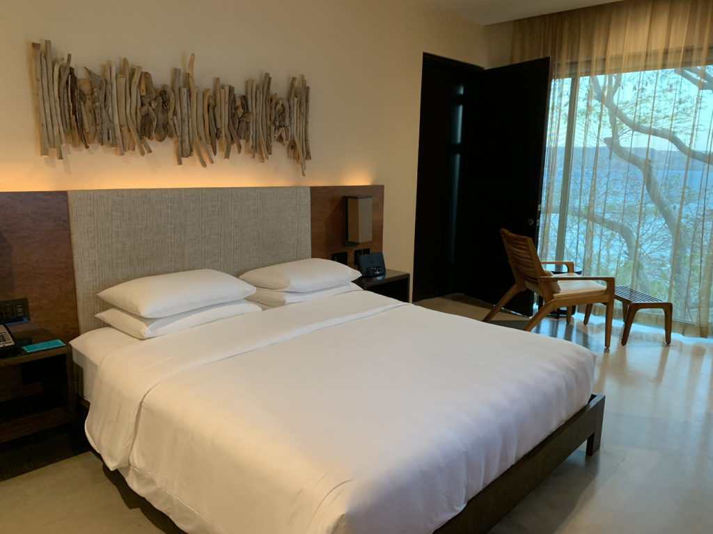 a bed in a room with a chair and a door