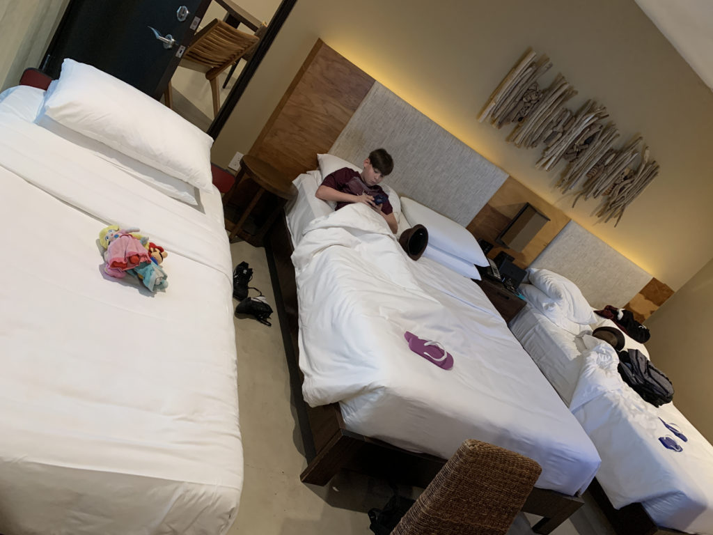 a boy lying on a bed in a hotel room