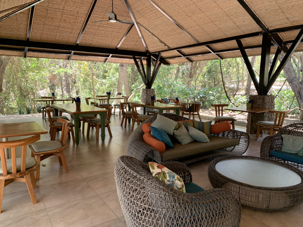 a covered patio with tables and chairs