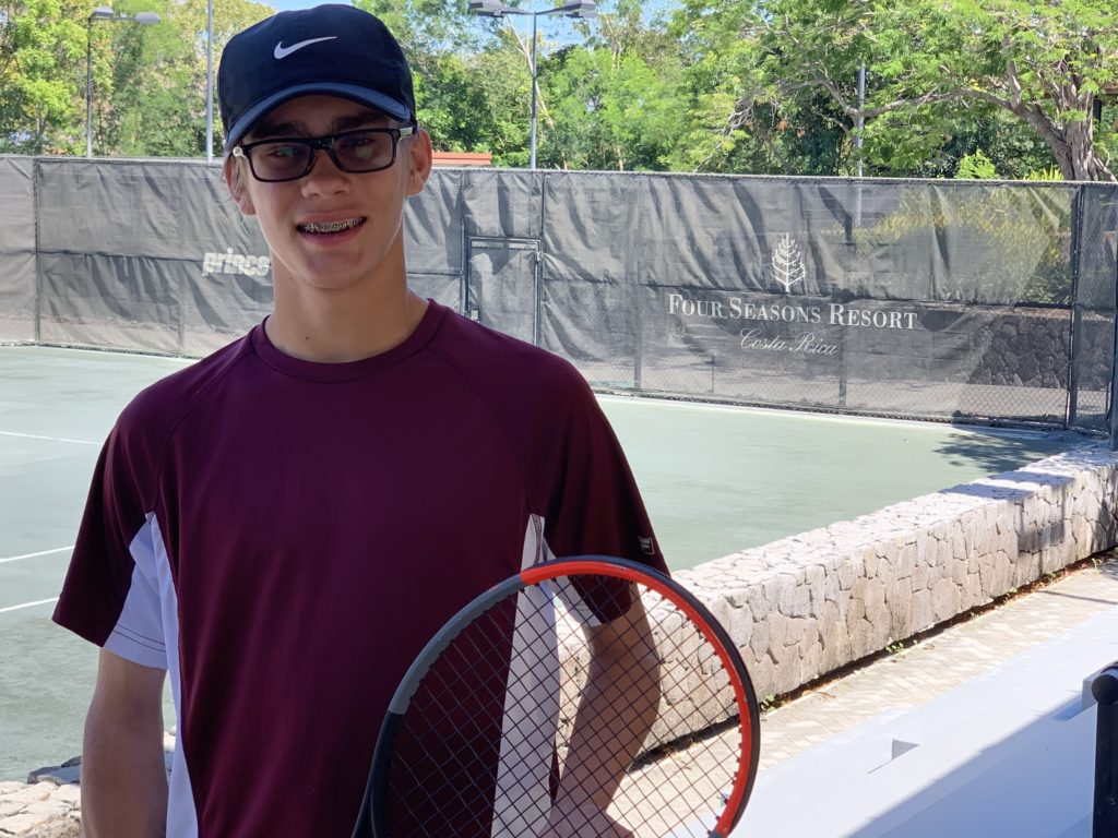 a boy holding a tennis racket
