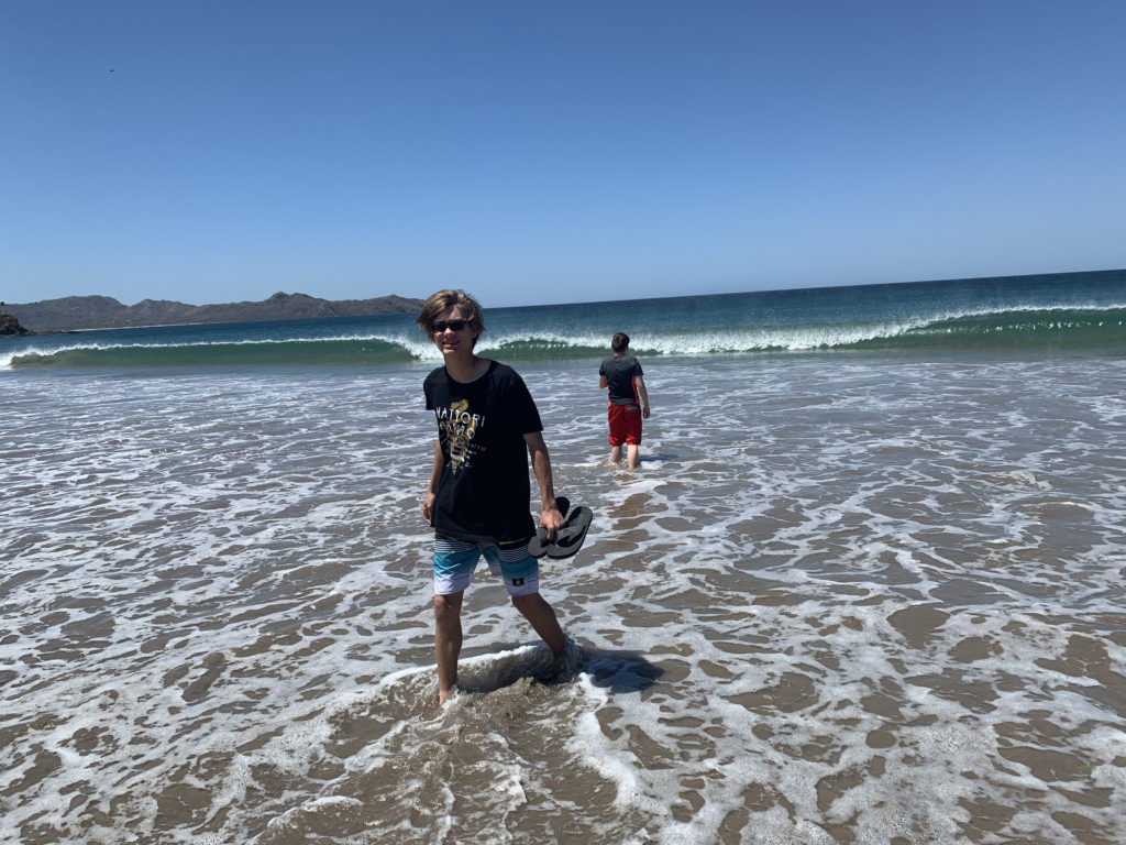 a man standing in the water with a pair of feet in the water
