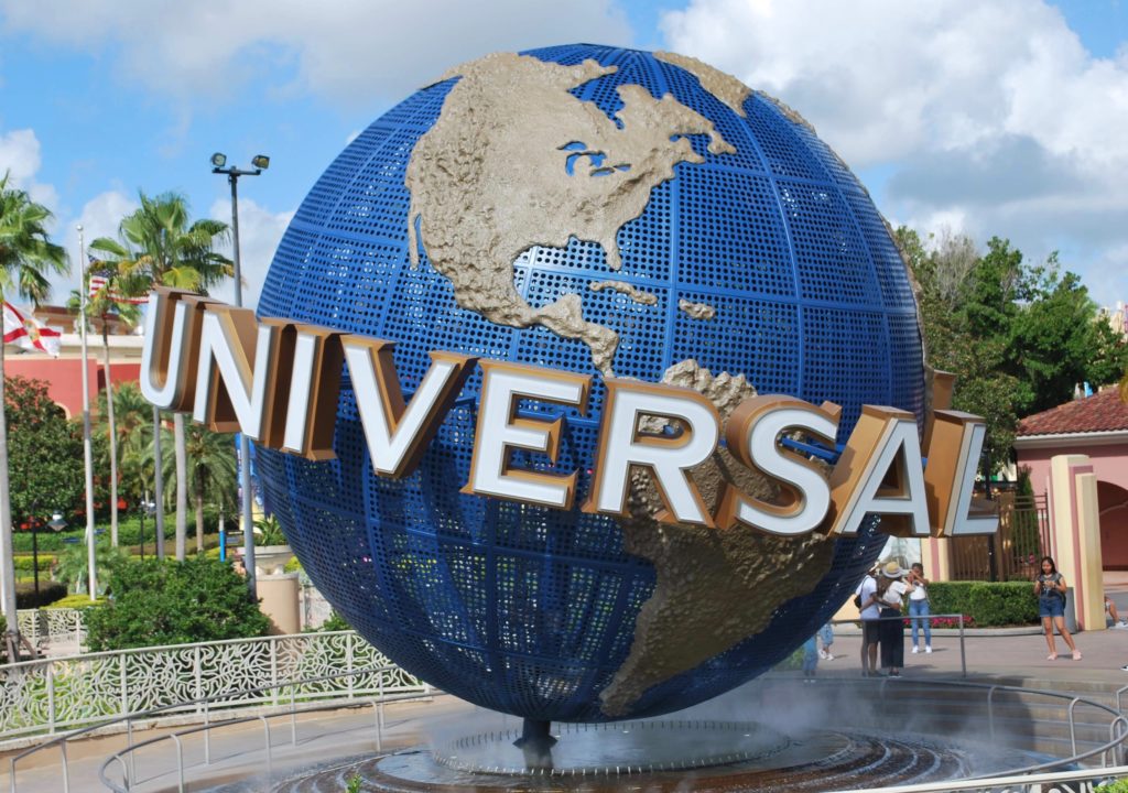 a large globe with a sign in the middle of it