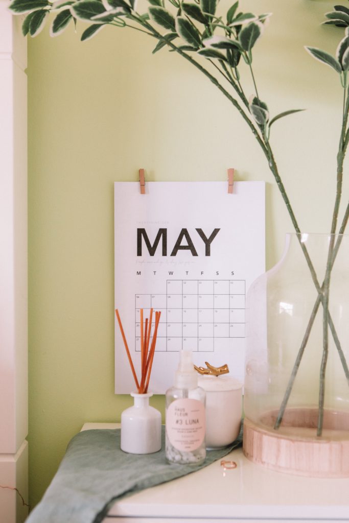 a calendar with a plant and bottles on a table
