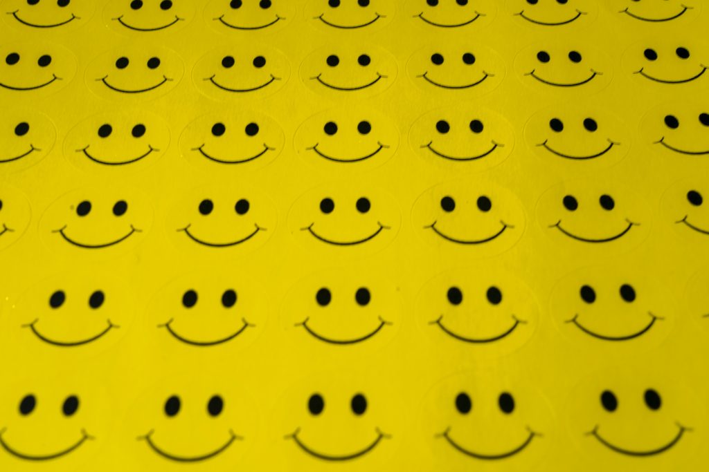 a group of smiley faces on a yellow background