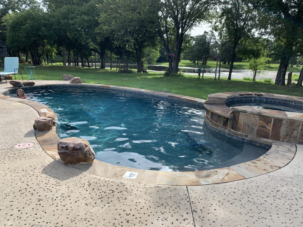 a pool with a stone walkway around it