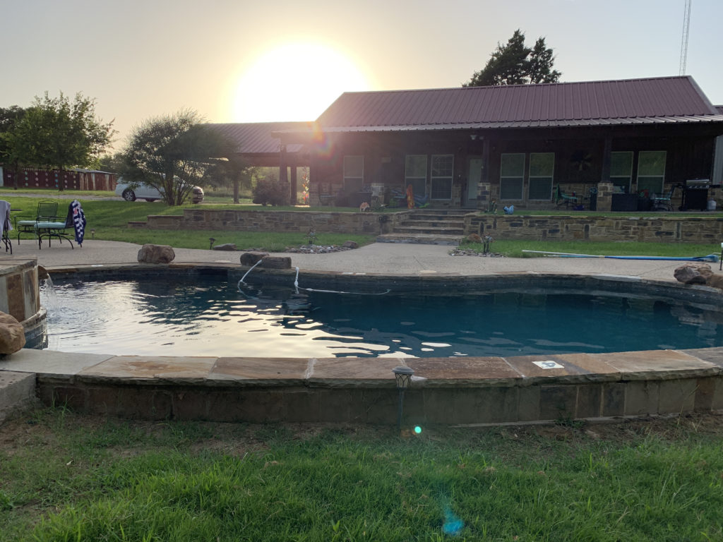 a pool in a backyard with a house and a building