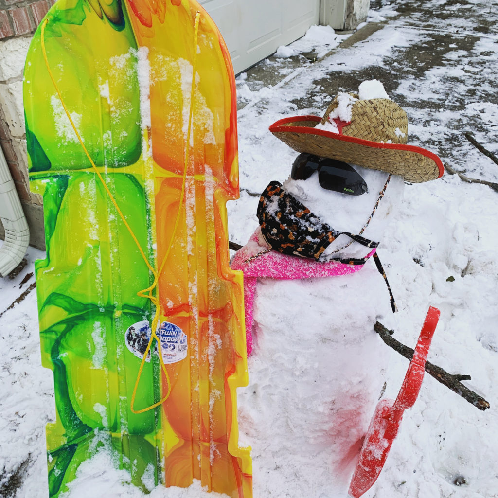 a snowman with a sled and hat