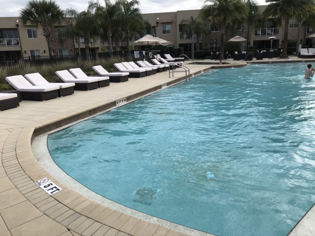 a pool with lounge chairs and umbrellas