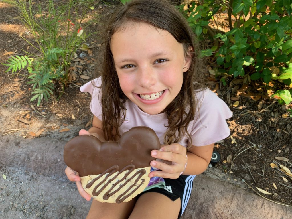 a girl holding a heart shaped cookie