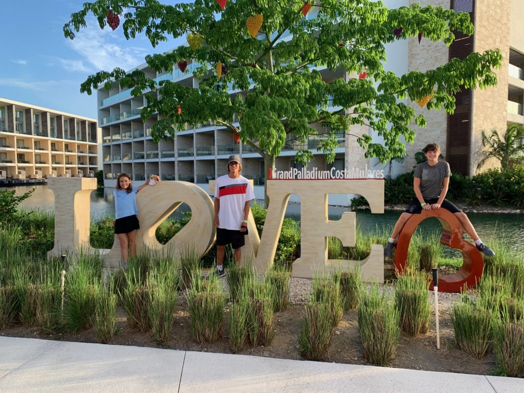a group of people posing in front of a large sign