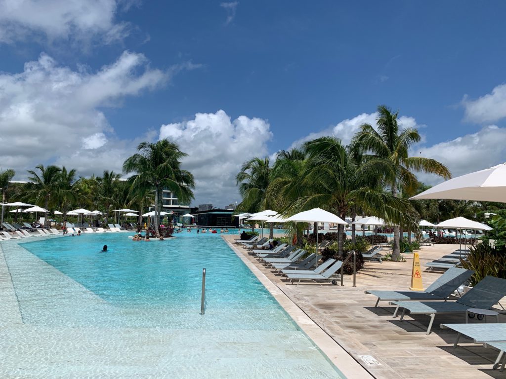 a pool with lounge chairs and umbrellas