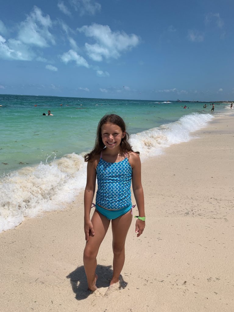 a girl standing on a beach