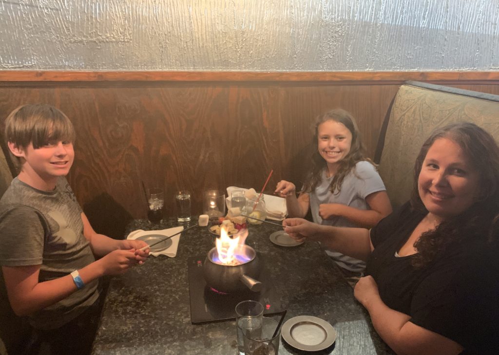 a group of people sitting at a table with a fire on top