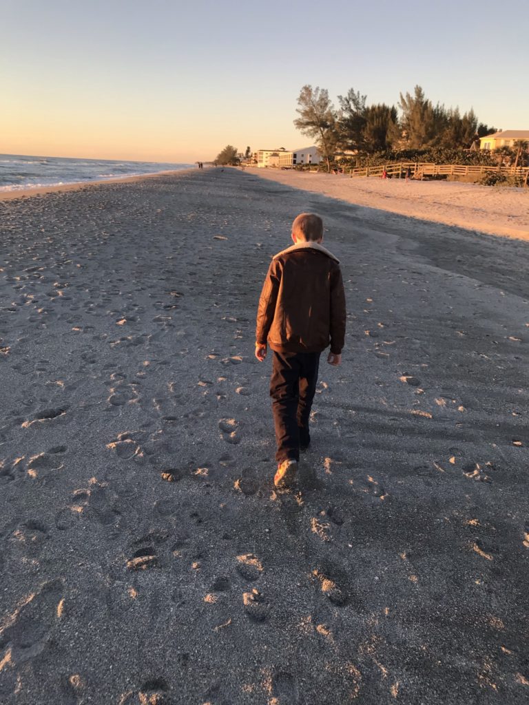 a boy walking on a beach