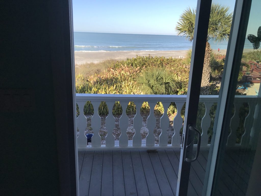 a balcony with a view of the ocean and trees