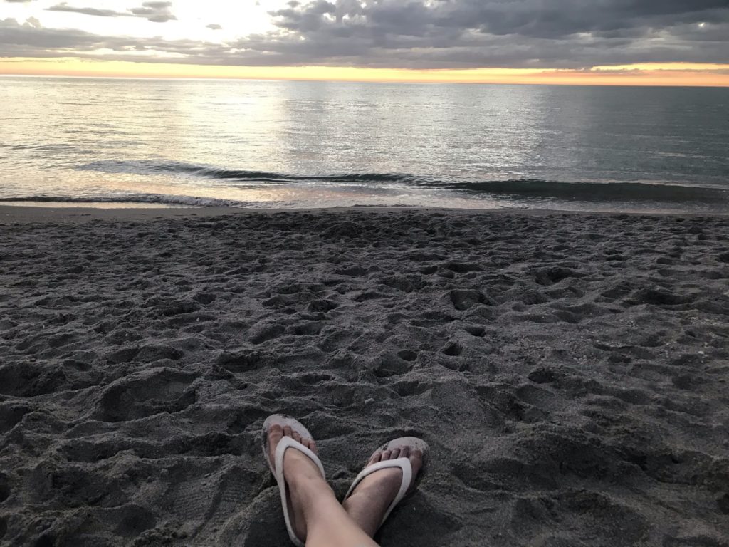 a person's feet in sand on a beach