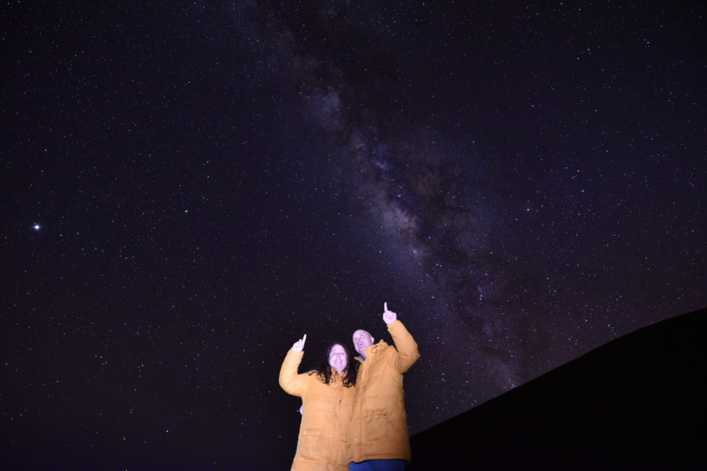 two people standing in front of a starry sky