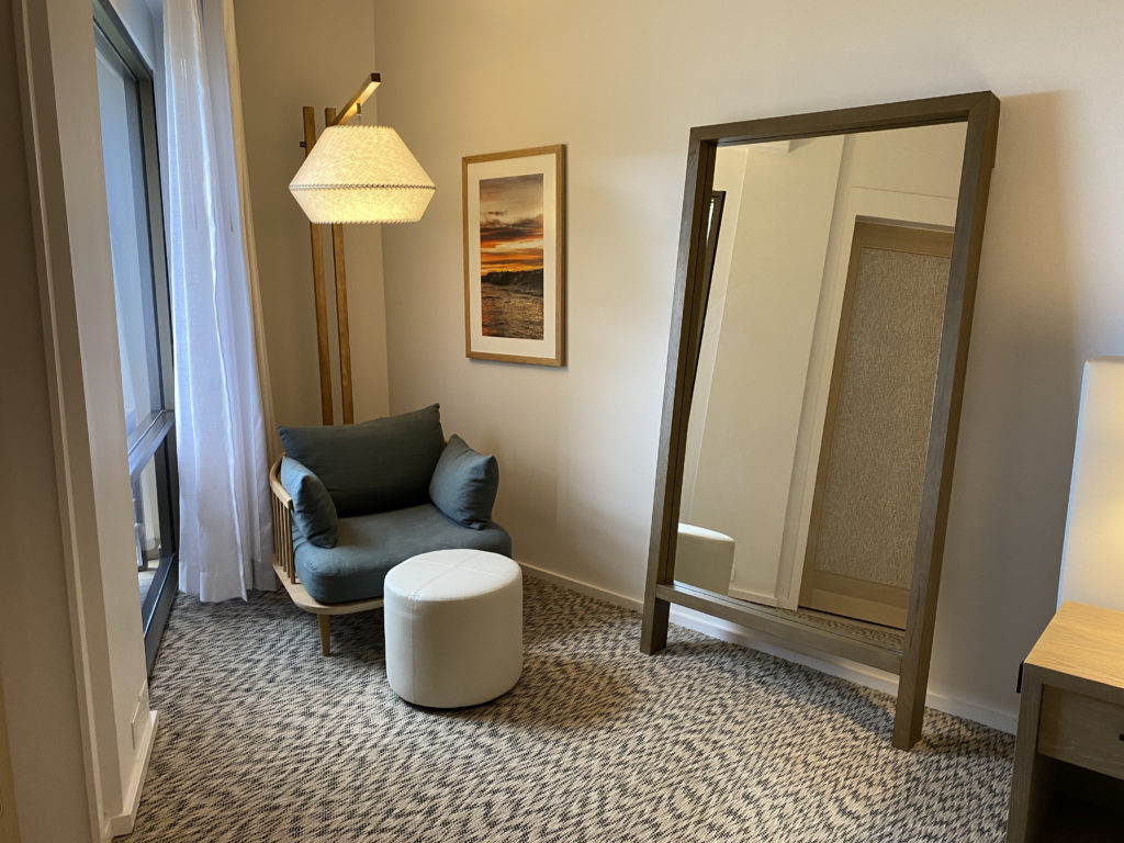 a room with a large mirror and a chair