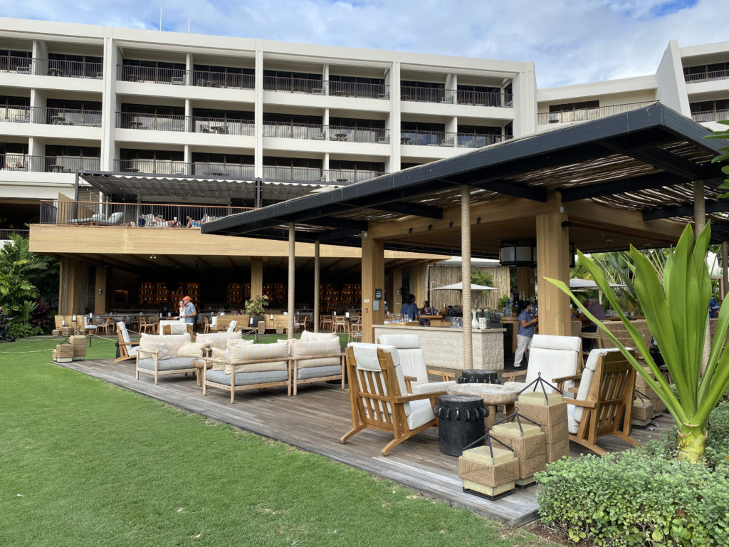 a patio with chairs and tables in front of a building