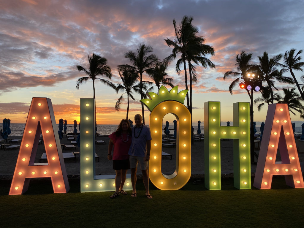 a couple standing in front of a sign