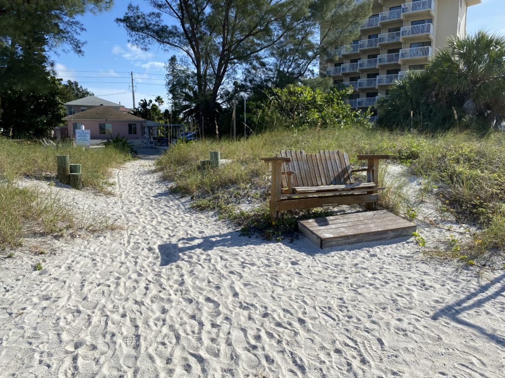 a wooden bench in a sandy area
