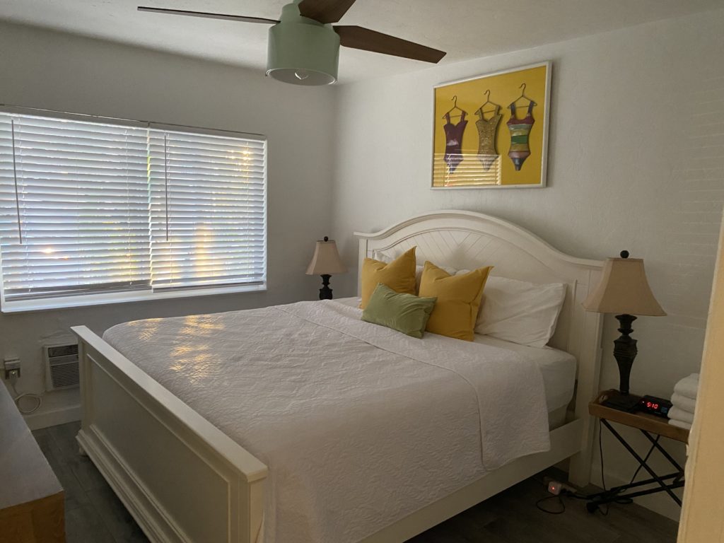 a bed with a fan and a poster on the wall