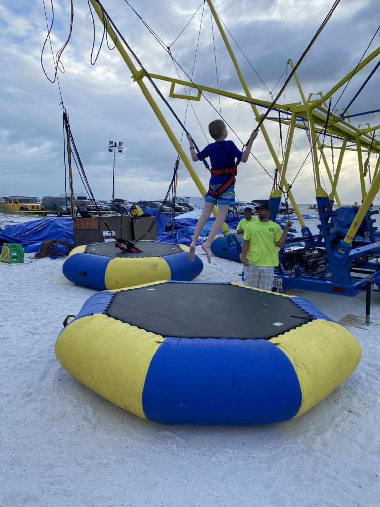 a boy jumping on a trampoline