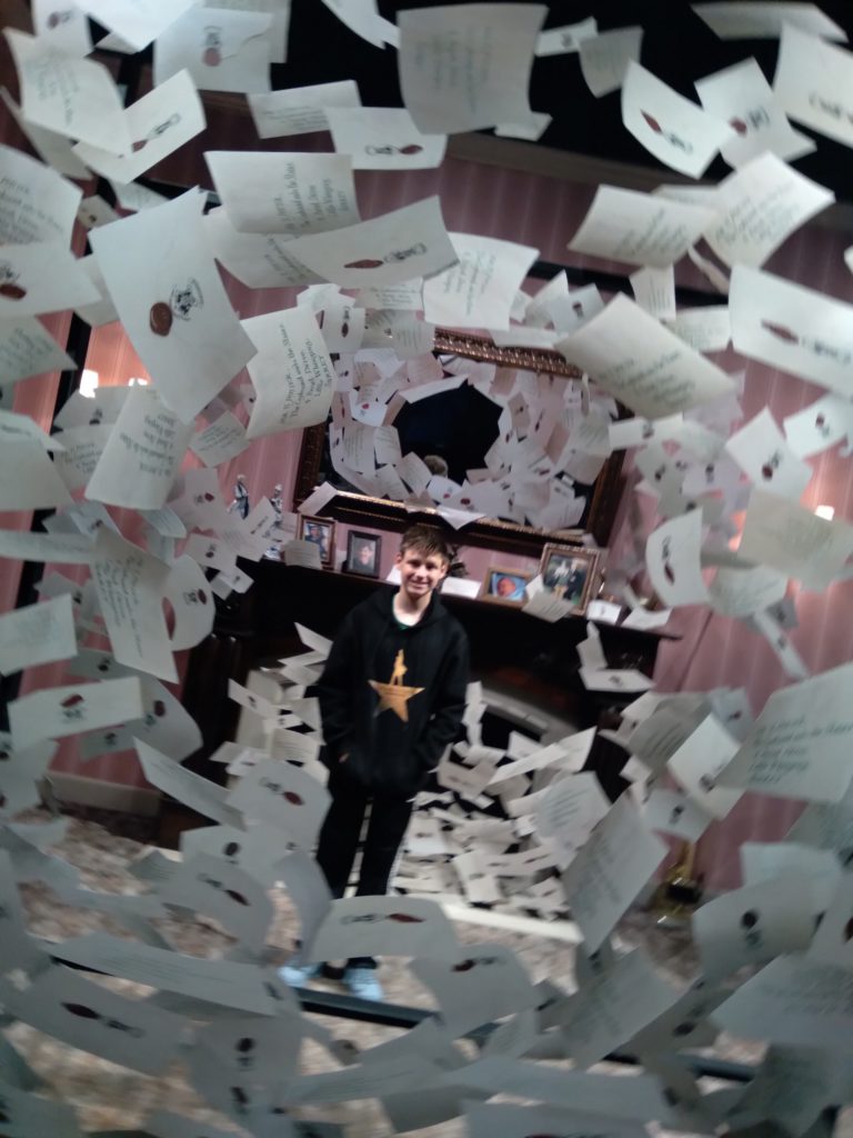 a man standing in a room with many white papers flying in the air