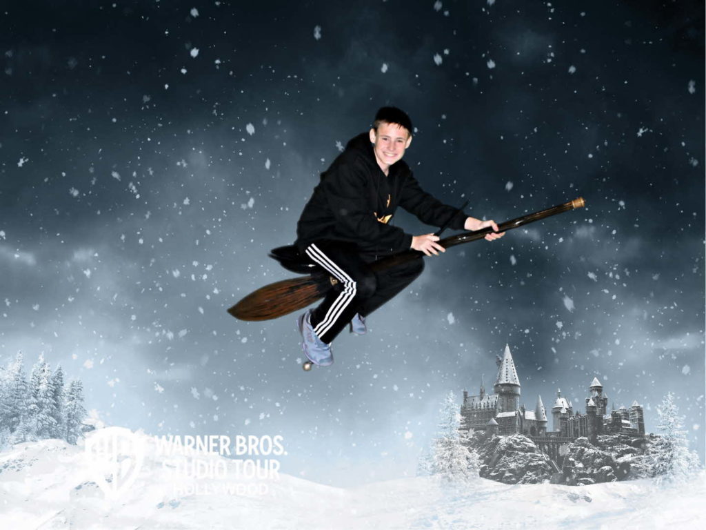 a boy flying on a broomstick in the snow