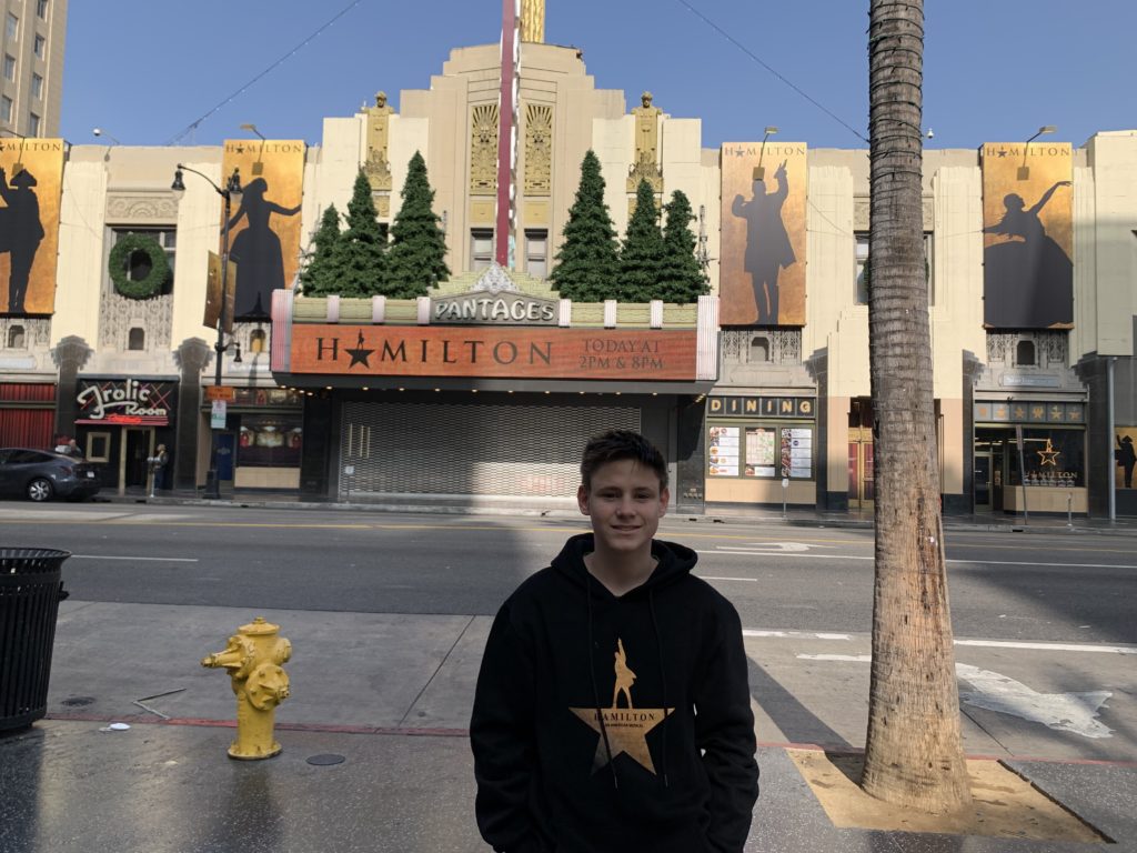 a boy standing in front of a building