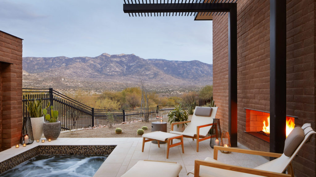 a patio with a hot tub and chairs