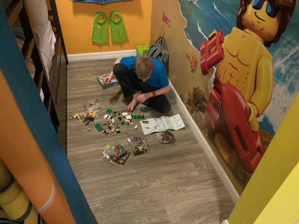a boy sitting on the floor with toys on the floor