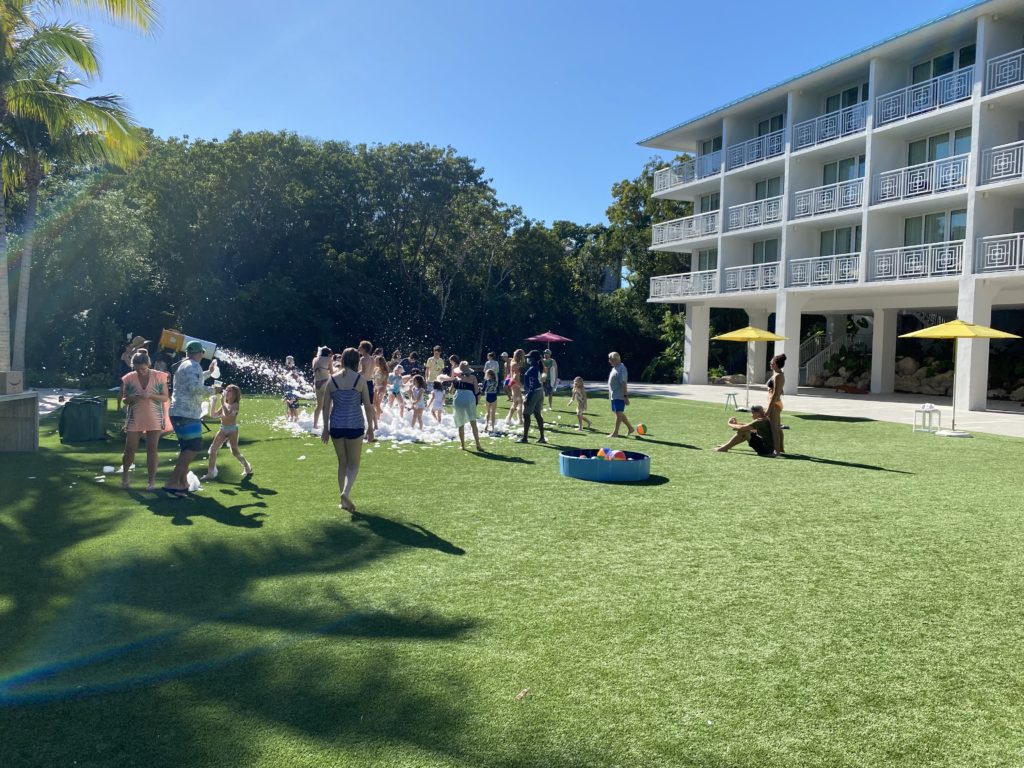 a group of people playing with water in a grassy area