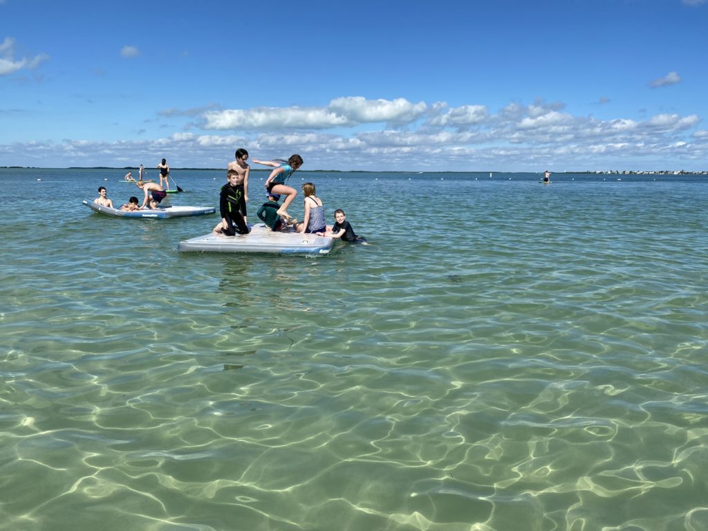 a group of people on a floating board in the water