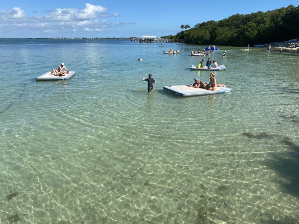 people on floating rafts in a body of water