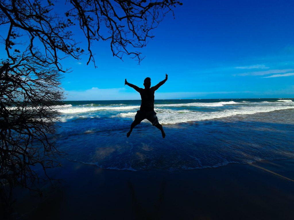 a man jumping in the air at the beach