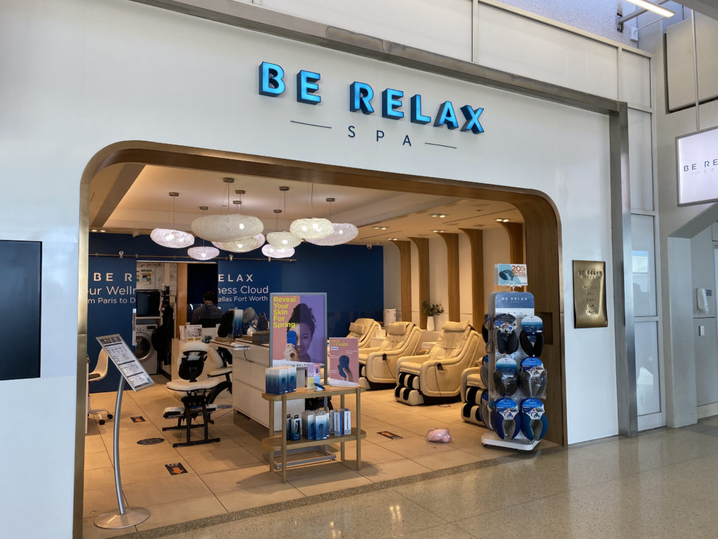 a store front with a sign and chairs