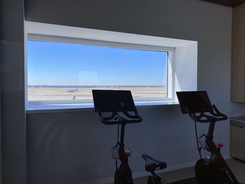 exercise bikes in a room with an airplane in the background